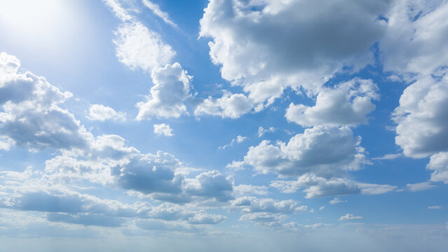 Blue sky with clouds at beautiful sunny day as natural background.