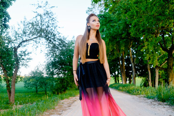 Fototapeta premium Woman in a summer dress on a near the bushes.