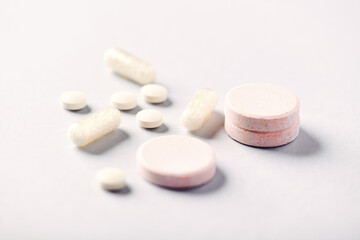 Collagen effervescent Tablets and Vitamin C tablets and capsules. Supplements to support collagen production. Bright paper background. Soft focus. Close up.	