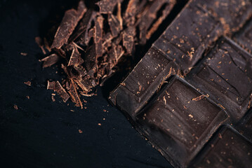 Bitter chocolate pieces on a wooden table, close up, macro photography