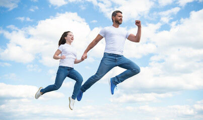 Fototapeta na wymiar energetic father and daughter jump in sky