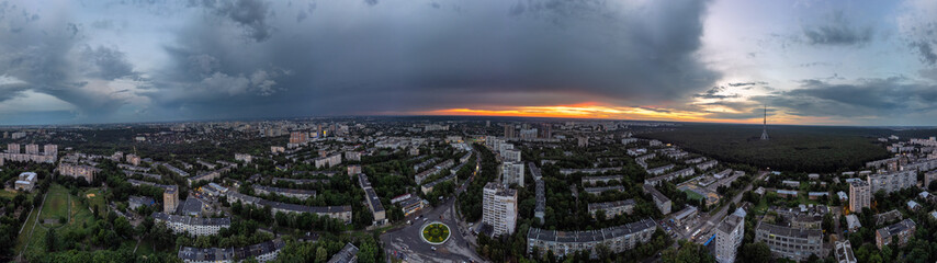 Epic wide sunset aerial urban panorama view in city residential district. Pavlovo Pole, Kharkiv, Ukraine. Evening skyscape, cloudscape and streets