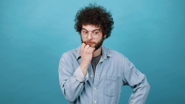 Bearded young man with kinky hair thinks of problem solution