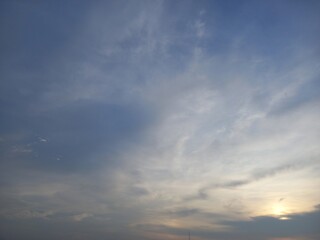 Naklejka na ściany i meble light blue sky with little cirrus cloud and shiny sun set at bottom right side