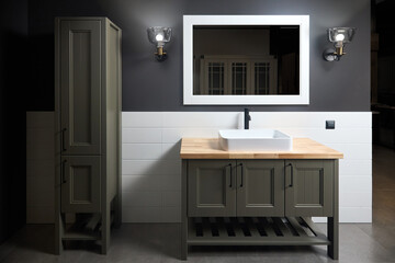 Wooden countertop bathroom with ceramic tiled wall stoneware tiled floor. Gray rustic flat loft bathroom with modern countertop basin, illuminated mirror lanterns and wooden PVC cupboard