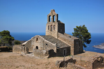 Fototapeta na wymiar The romanesque church of Santa Helena de Rodes with its bell tower at the Mediterranean Sea in Catalonia, Spain
