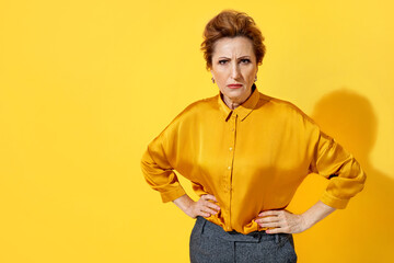Angry woman in yellow shirt on yellow background