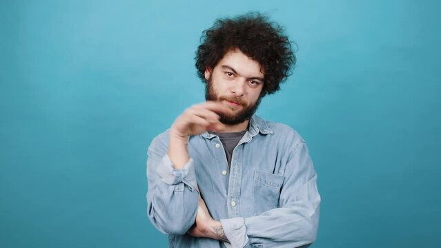 Indignant man with kinky hair shows bla-bla-bla gesture