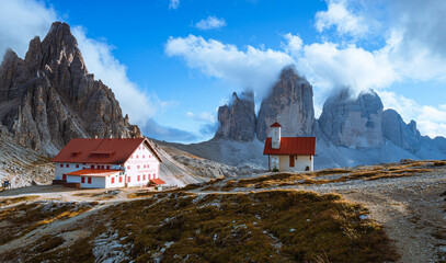 One of the most famous and spectacular views of all the Alps: the locatelli refuge, its church and the three peaks of Lavaredo, inside the Three Peaks-Sesto Dolomites Natural Park - October 2021.