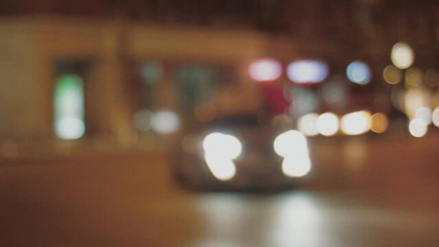 Blurred vision of city at night with traffic lights with a bus and cars passing by