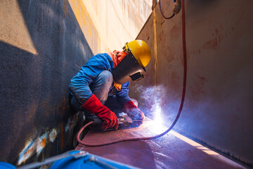 Male worker wearing protective clothing and repair welding industrial construction oil and gas or...