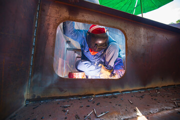 Male worker wearing protective clothing and repair pontoon manhole welding industrial construction...