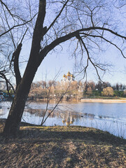 Obraz premium Orthodox church with golden cupola by the riverside, early springtime 