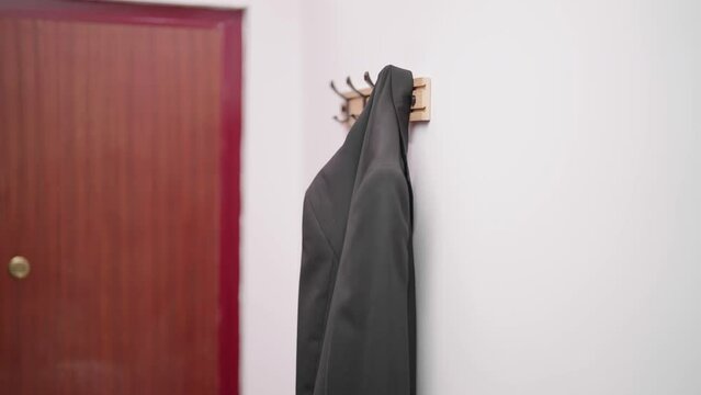 Person hand hang a business suit on hook 4K