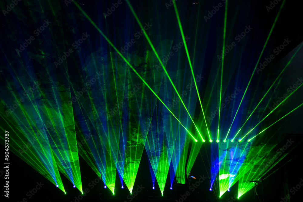 Wall mural laser show beams. many colorful rgb lazer light beams at a concert or a rave party show. night club 