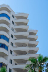 View of a small part of a beautiful white building with large balconies.