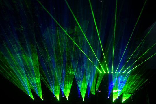 Laser show beams. Many colorful rgb lazer light beams at a concert or a rave party show. Night club flyer design background. Digital party club event.