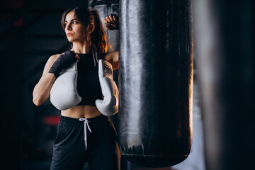 Fototapeta na wymiar Young woman boxer training at the gym