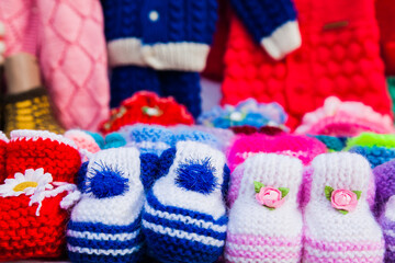 Fototapeta na wymiar Knitted baby booties in other knitted things on the background