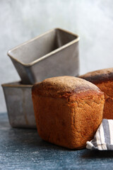 Rectangular bread and aluminum forms on a table. Freshly homemade baked rye bread close up photo. 