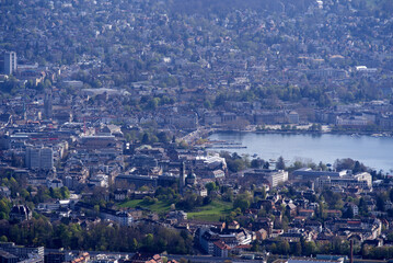 Fototapeta premium Panoramic view over City of Zurich with lake Zurich seen from local mountain Uetliberg on a summer day morning. Photo taken April 14th, 2022, Zurich, Switzerland.