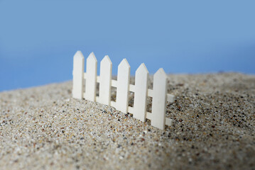 Barrière miniature blanche en bois dans le sable