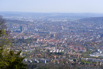 Fototapeta na wymiar Panoramic view from local mountain Uetliberg over City of Zürich on a blue cloudy spring day. Photo taken April 14th, 2022, Zurich, Switzerland.