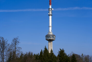 Obraz premium Communications tower at local mountain Uetliberg on a blue cloudy spring day. Photo taken April 14th, 2022, Zurich, Switzerland.