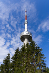 Fototapeta premium Communications tower at local mountain Uetliberg on a blue cloudy spring day. Photo taken April 14th, 2022, Zurich, Switzerland.