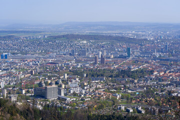 Fototapeta na wymiar Panoramic view from local mountain Uetliberg over City of Zürich on a blue cloudy spring day. Photo taken April 14th, 2022, Zurich, Switzerland.