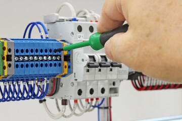 Mounting screwdriver in the hand of an electrical engineer close-up.