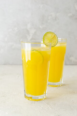 Homemade orange lemonade in glasses with lime slices.