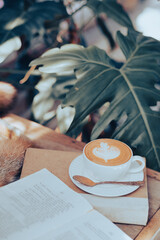 A cup of coffee on the table with notebook-vintage filter
