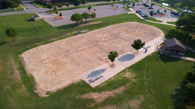 Aerial footage of Bear Creek Park in Keller Texas.  Camera flies over sand volleyball court.