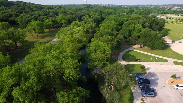 Aerial footage of Bear Creek Park in Keller Texas. Camera starts east and heads west along creek.