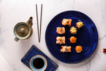 baked hot sushi rolls on a dark background. Hot fried Sushi Roll Sushi menu Set of sushi food with copy space Set of sushi with wasabi, soy sauce and teapot on black stone background