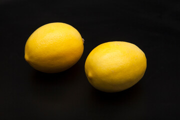 Fresh yellow lemons on a black background