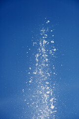 Water splashing from the fountain in the background of blue sky