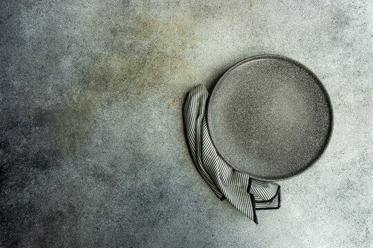 Overhead view of a grey ceramic plate and napkin on a table