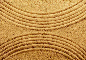 Fototapeta na wymiar Pattern of smooth abstract lines on the summer sand.