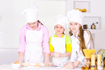 Portrait of three girls cooking on kitchen