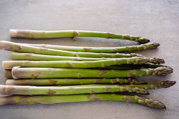 Gourmet veggies green asparagus on a grey stone background, close up. Healthy eating, healthy lifestyle concept.