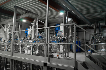 Industrial stainless steel vats. Factory interior, steel pipelines, tubes. Equipment for the production of organic fertilizers. Large reservoirs or tank