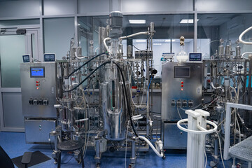 Industrial stainless steel vats. Factory interior, steel pipelines, tubes. Equipment for the production of organic fertilizers. Large reservoirs or tank