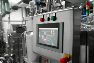 Equipment control station. Factory interior, steel pipelines, tubes. Equipment for the production...