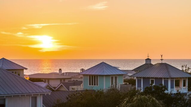 High angle aerial timelapse time lapse view colorful sunset with sea ocean landscape of Gulf of Mexico in Seaside, Florida roof houses cityscape 