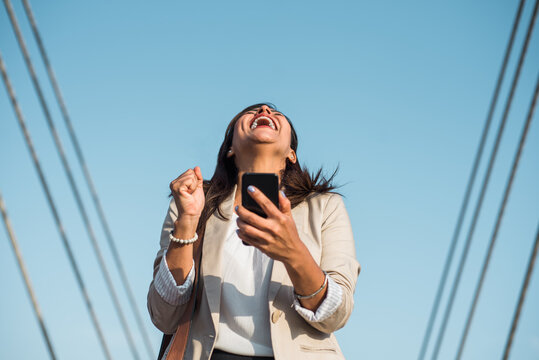 portrait of a businesswoman laughing to the sky in happiness because she won an award
