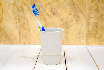 Toothbrush stands in a glass on a beige background
