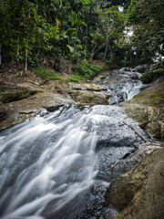 Naklejka na ściany i meble a small river flows from the Pinang Seribu waterfall, Samarinda