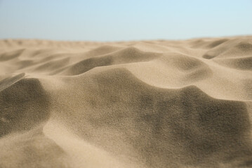 Closeup view of sand on beach under blue sky - Powered by Adobe
